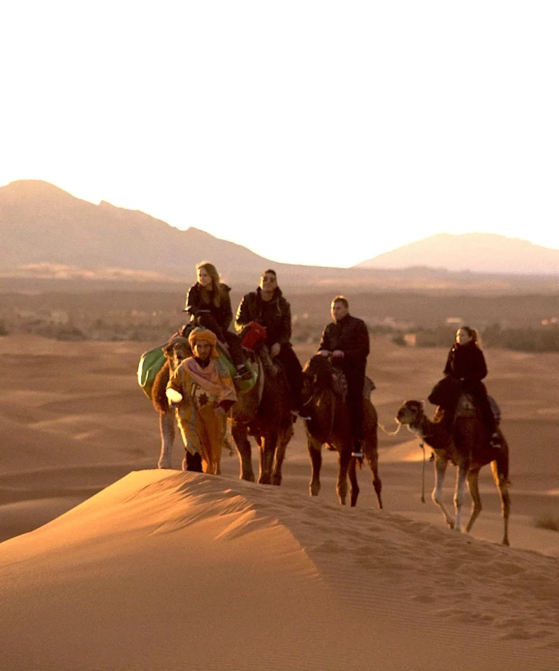 Tourists riding camels on Sahara sand dunes – 12-day Tangier to Marrakech tour – Epic Zagora Tours